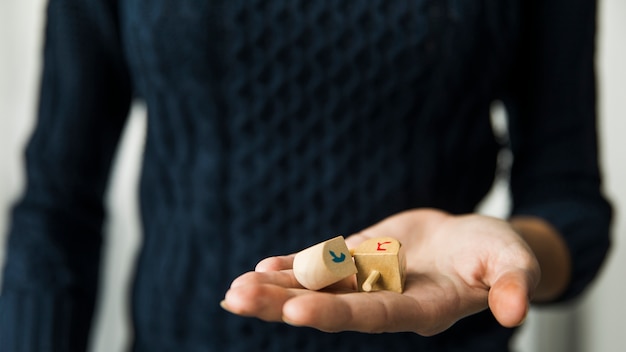 Crop woman holding dreidels