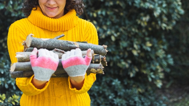 Foto gratuita raccolga il mucchio della tenuta della donna di legna da ardere