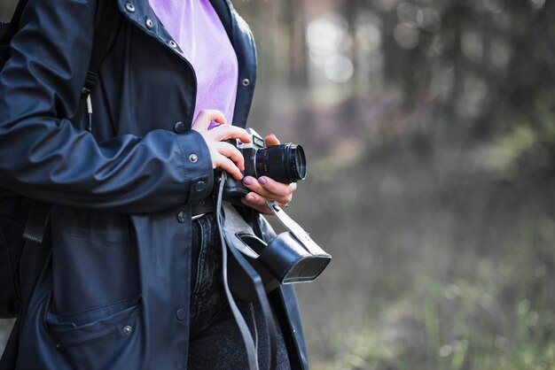 Crop woman holding retro camera