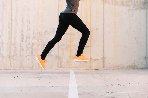 crop woman leaping on training