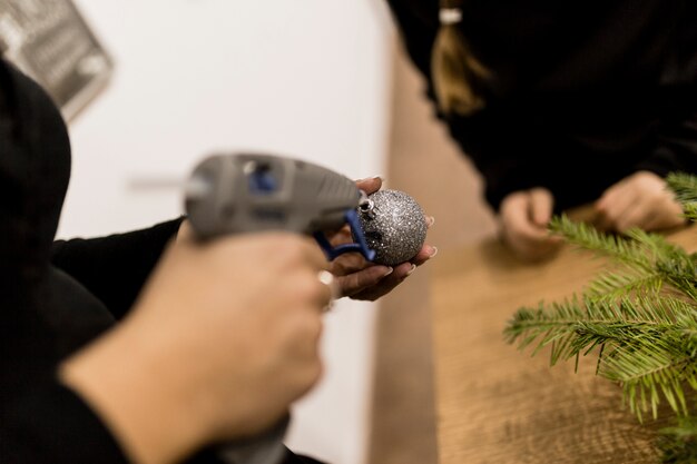 Crop woman making bauble