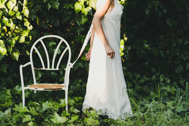 Crop woman near chair in garden