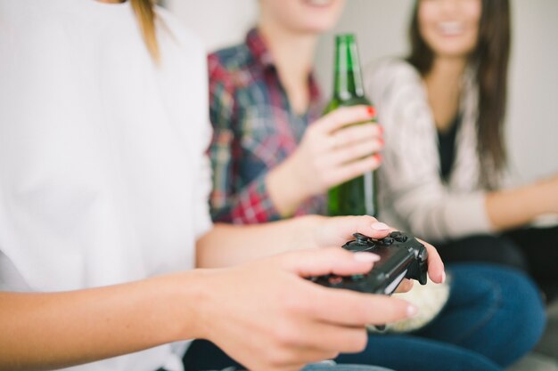 Crop woman playing videogame with friends