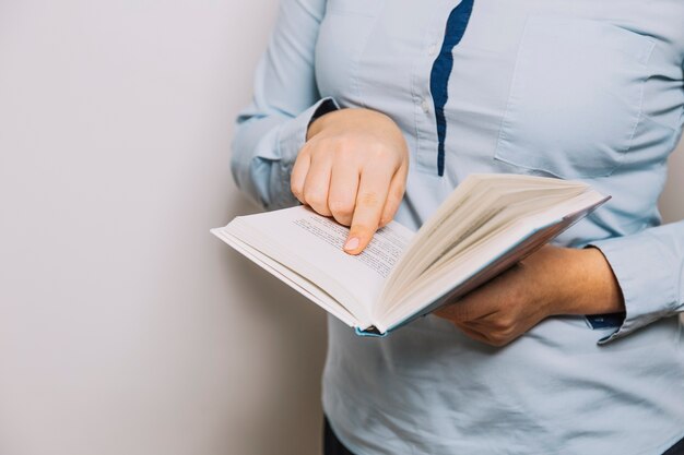 Crop woman pointing at book page