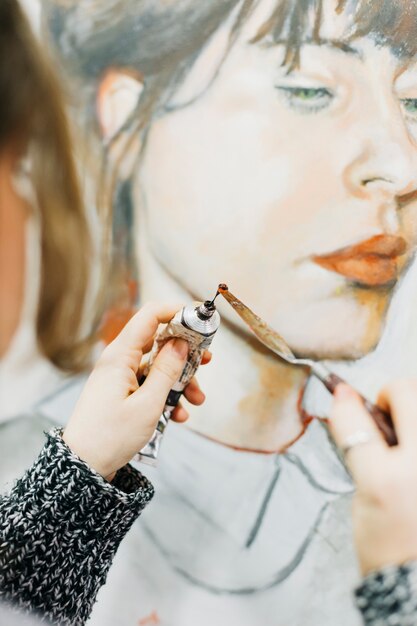 Free photo crop woman putting paint on spatula