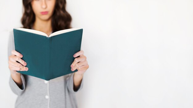 Crop woman reading book