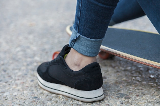 Crop woman resting on longboard