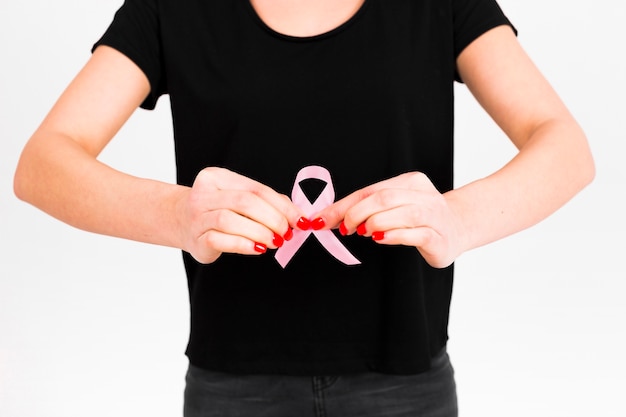 Crop woman showing pink ribbon