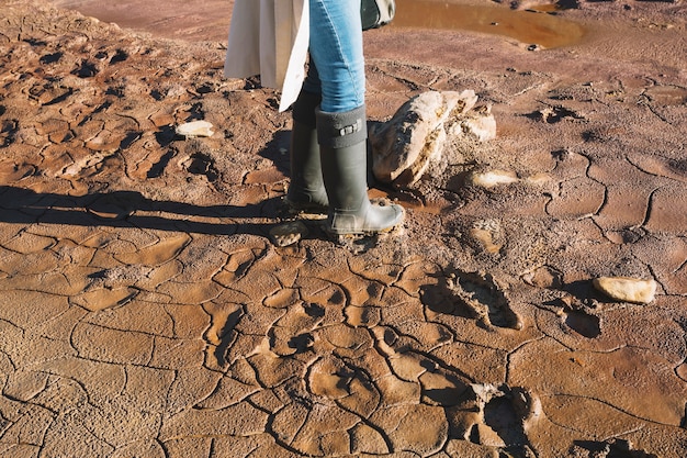 Crop woman standing in mud