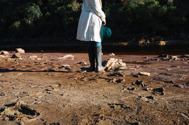 Free photo crop woman standing in rubber boots