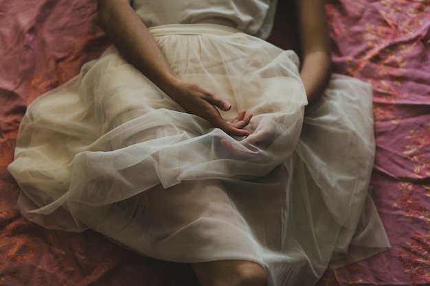 Crop woman in white skirt on floor