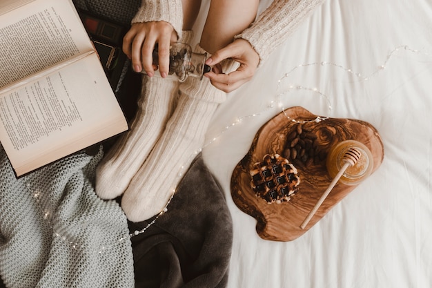 Foto gratuita raccolga la donna con le ghiande vicino ai dolci e libro