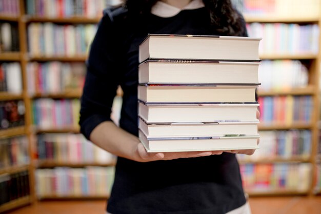 Crop woman with books in library