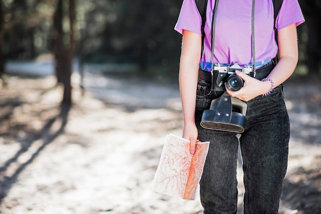 Crop woman with camera and map 