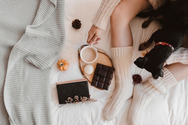 Foto gratuita raccolga la donna con il cane che beve sul letto