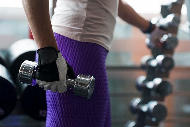 Crop woman with dumbbell