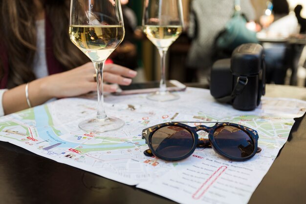 Crop woman with map sitting at table