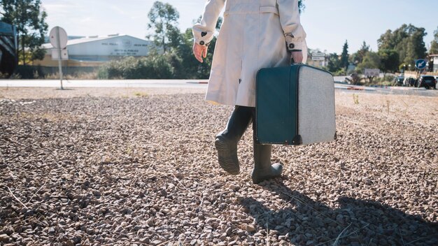 Crop woman with vintage suitcase