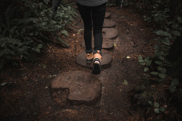 Crop woman on wooden path