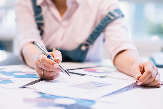 Crop woman working with charts