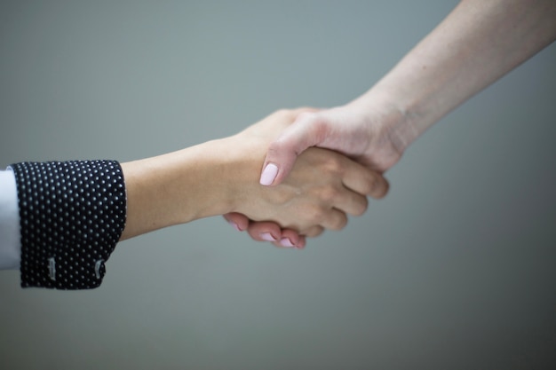 Crop women shaking hands