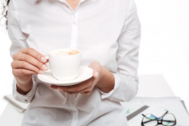 Cropped image of african business woman drinking coffee