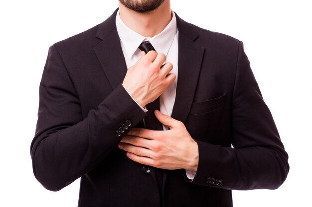 Cropped image of businessman fixing tie isolated on grey