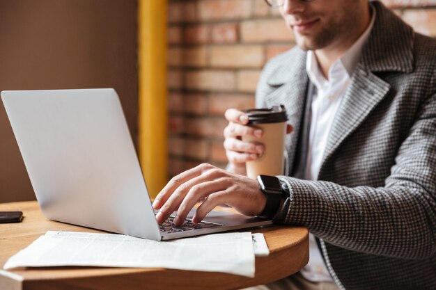 Cropped image of businessman sitting by table in cafe