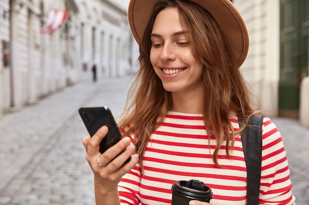 Cropped image of charming tourist uses application on cellular