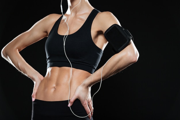 Cropped image of  fitness woman holding arms on hips