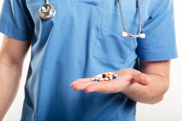 Cropped image of a male doctors palm with pills