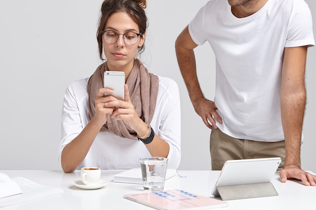 Cropped image of serious woman chooses video on mobile phone in internet website