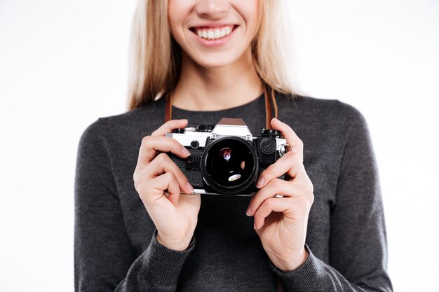 Обрезанное изображение улыбающейся блондинки с ретро-камерой