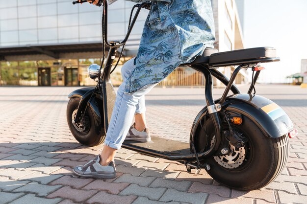 Cropped image of a woman sitting on a motor bicycle