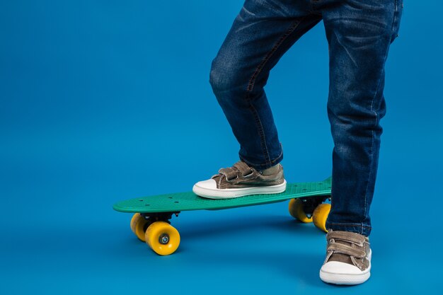 Cropped image of young boy comes on skateboard