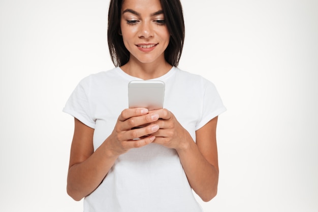 Cropped image of a young casual woman typing message