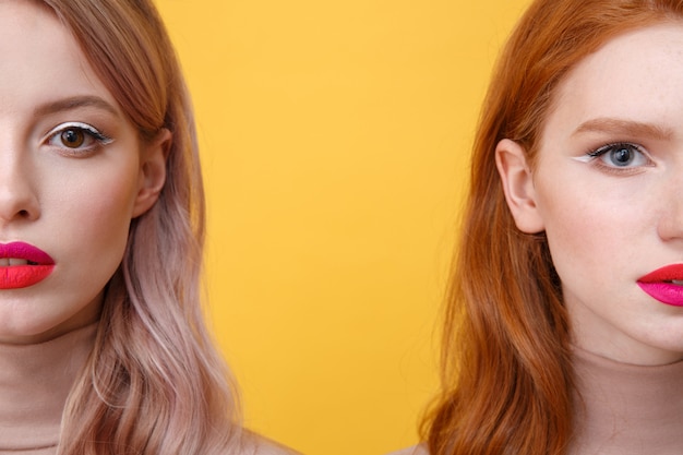 Cropped image of young two ladies with bright makeup lips