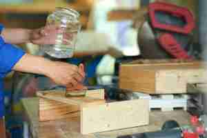 Free photo cropped joiner polishing wood at the workbench