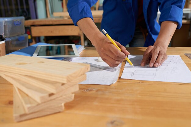 紙のシートに青の全体的な図面の家具を着て男をトリミング