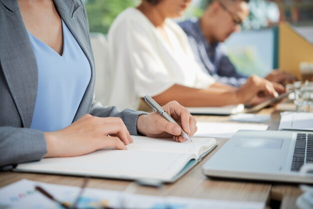 Cropped people performing their job duties in the coworking space