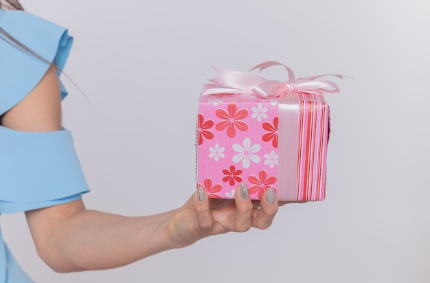 Cropped photo of hand of woman holding present celebrating international women's day standing over white wall