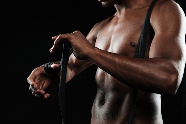 Cropped photo of the hands young afroamerican boxer, winds boxing bandages