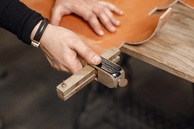 Cropped photo of mature craftsman's hands working in his workspace Man drawing a sketch Grounge dark stone texture background