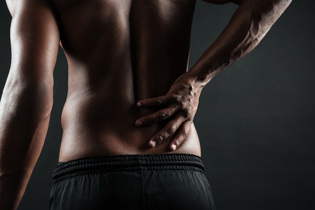 Free photo cropped photo of young afro american man with back pain