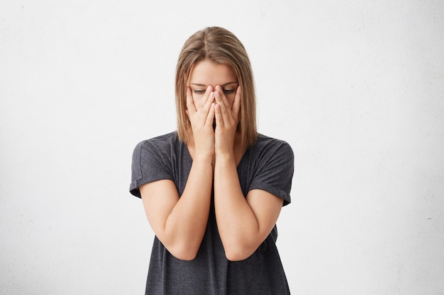 Free photo cropped portrait of sad tired woman covering face with hands having eyes full of pain and stress having fatigue. stressful beautiful woman having panic trying to concentrate and find solution.