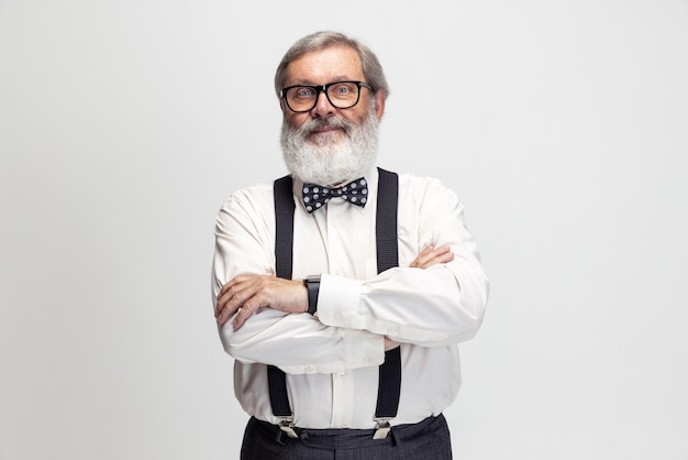 Cropped portrait of senior man in glasses, teacher, professor posing isolated over gray background