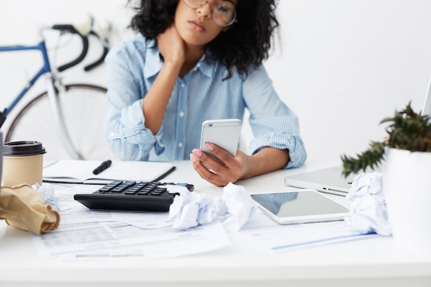 Free photo cropped shot of african american young female freelancer sitting at home at working table