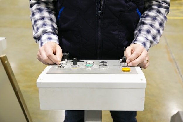 Free photo cropped shot of factory machine operator pressing buttons