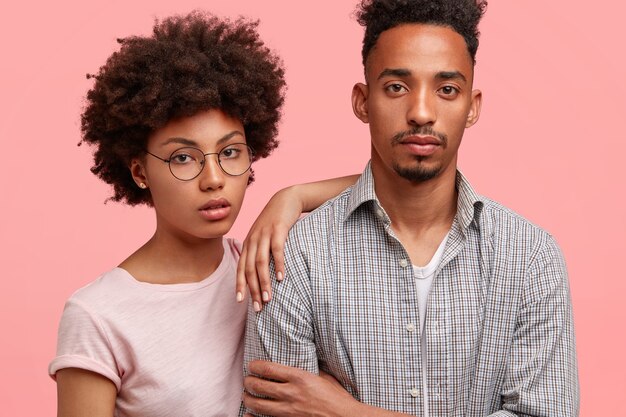 真面目な黒人女性と男性のパートナーのクロップドショットは思慮深い表情をしています