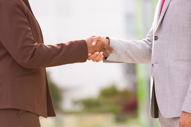 Free photo cropped shot of two people shaking hands